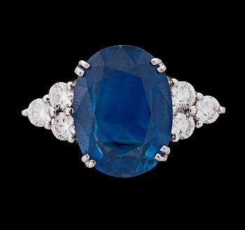 RING, oval fasettslipad blå safir, ca 4.50 ct med briljantslipade diamanter, tot. ca 0.60 ct.