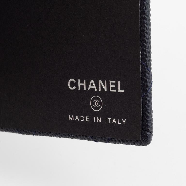 Chanel, a dark blue navy caviar leather notebook.