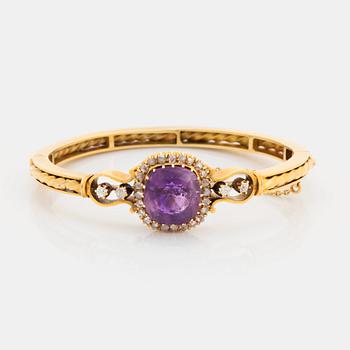 A 14K gold bangle set with a faceted amethyst and rose-and old-cut diamonds.