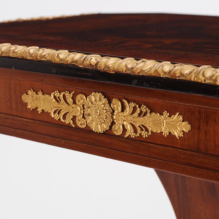 A north european Empire  'Umdruck'-decorated mahogny and gilded metal table.
