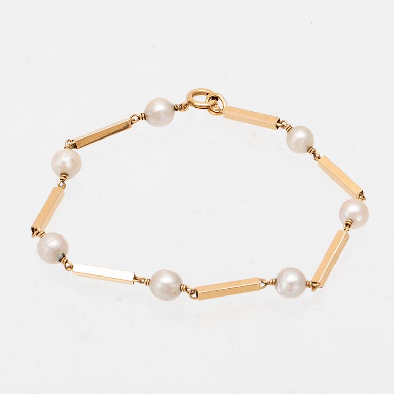 An 18K gold bracelet set with cultured pearls.