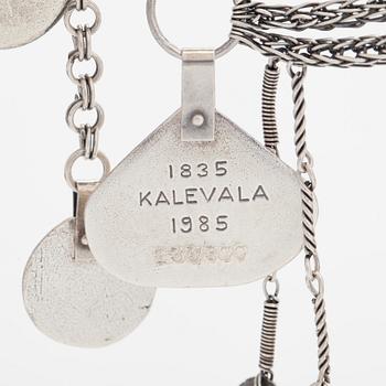 Juhlakääty ja korvakorut, Kalevala-eepos 150 vuotta, sterlinghopeaa. Kalevala Koru, Helsinki 1984 ja 1992.