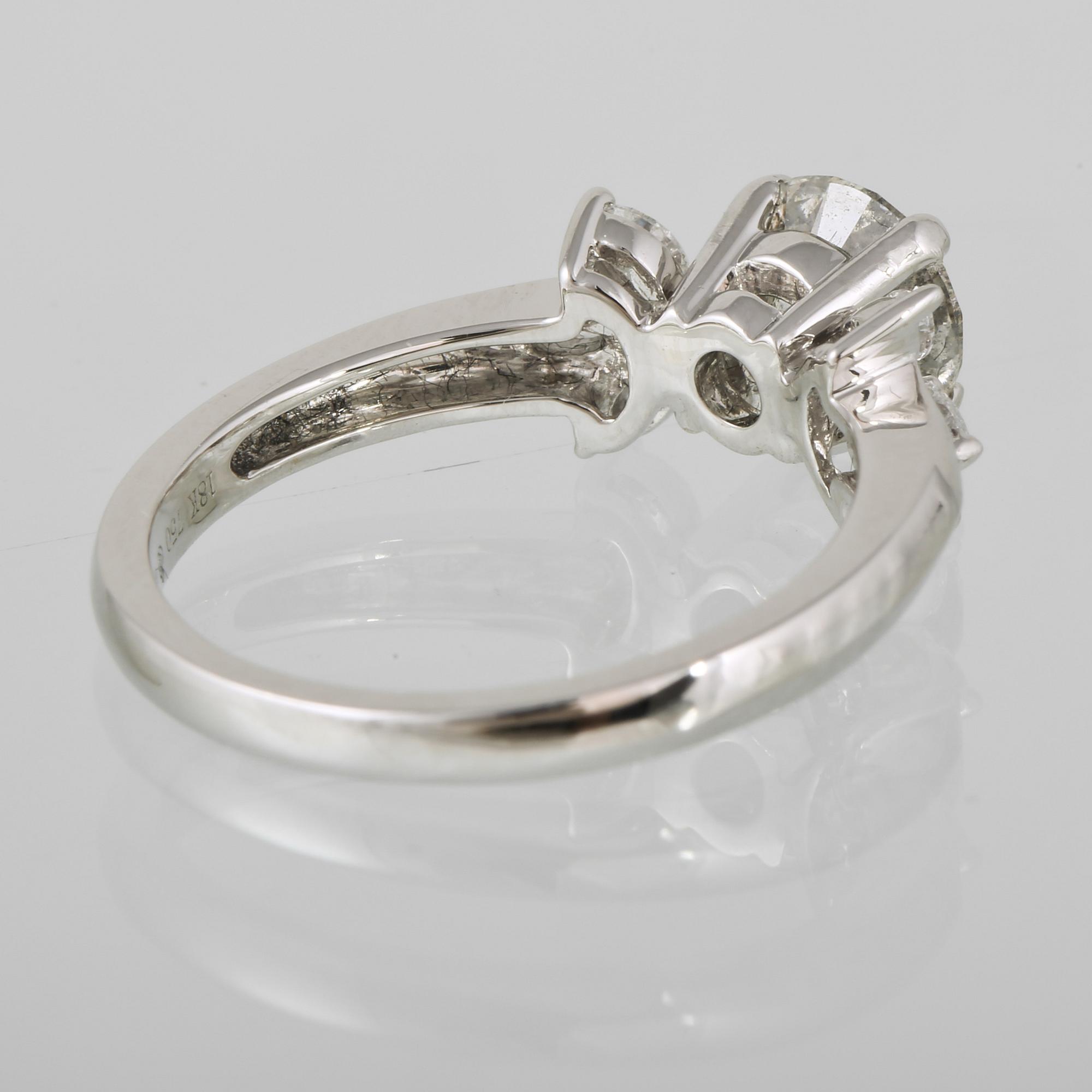 RING, 18K vitguld med briljantslipad diamant ca 1.22 ct samt navetteslipade diamanter 0.26 ct. Vikt 4,2 gram.