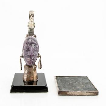 An amethyst and silver sculpture in the shape of a womans face with snake on her head, Mexico.