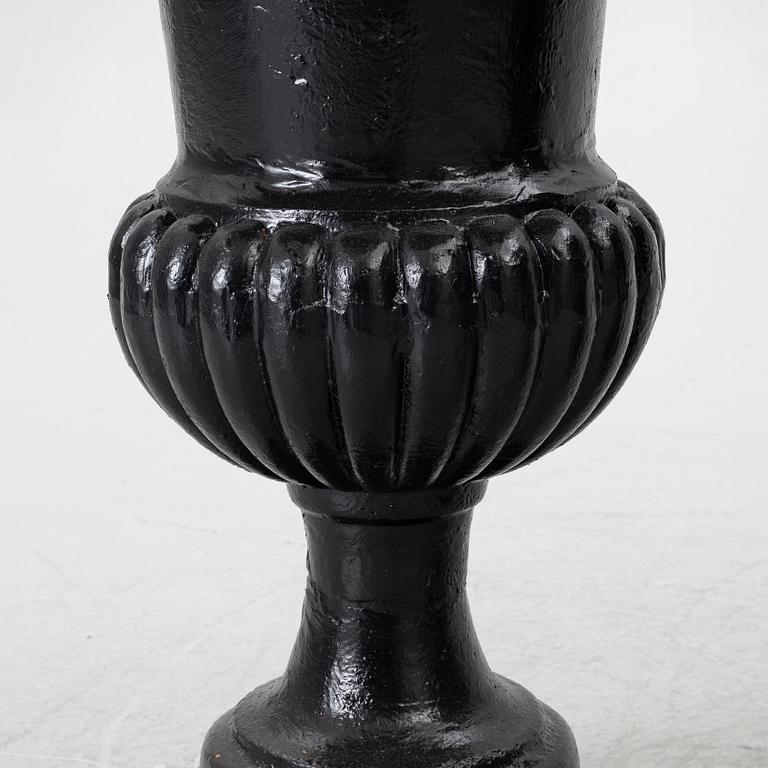 A pair of cast iron garden urns, 20th century.