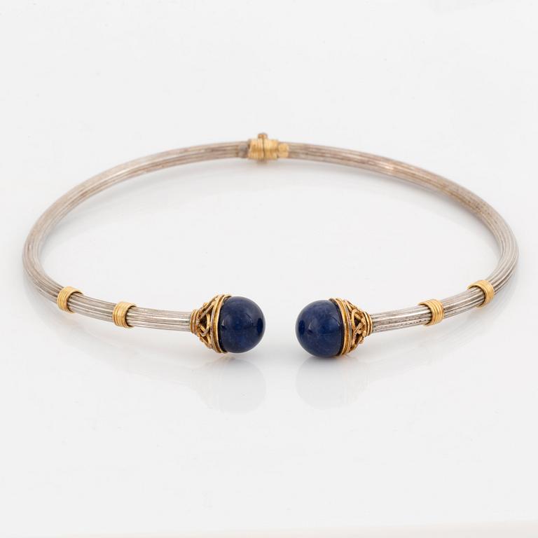 An Ilias Lalaounis demi parure comprising a necklace, a bracelet and a ring in silver and 18K gold set with sodalite.