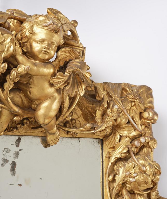 A presumably Dutch Louis XIV carved giltwood frame with mirror glass, in the style of Jean Le Pautre, late 17th century.