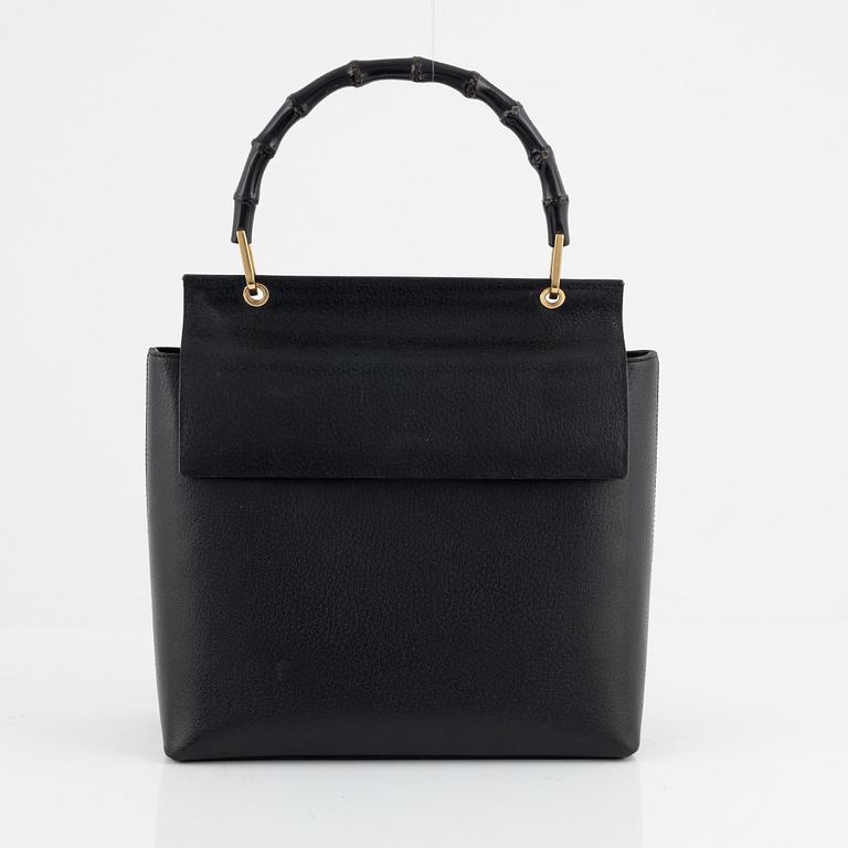 Gucci, a black leather and bamboo bag.