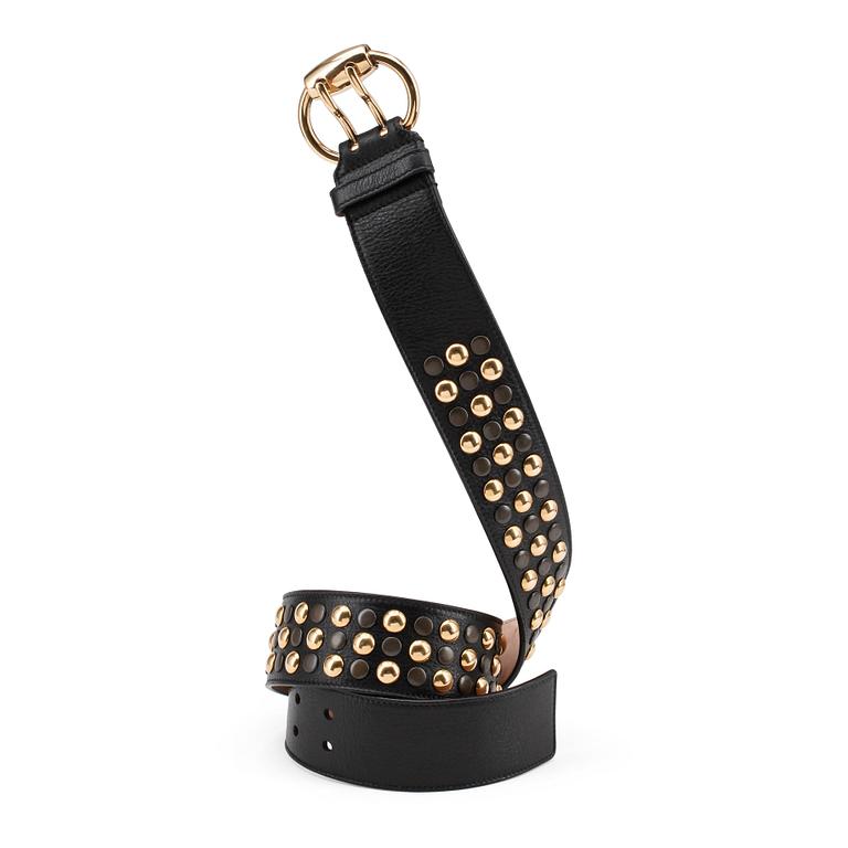 GUCCI, a black leather belt with goldcolored and patinated decor.