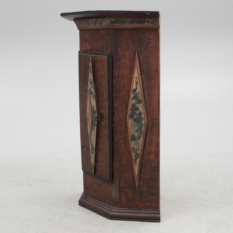 A corner cabinet, 18th Century.