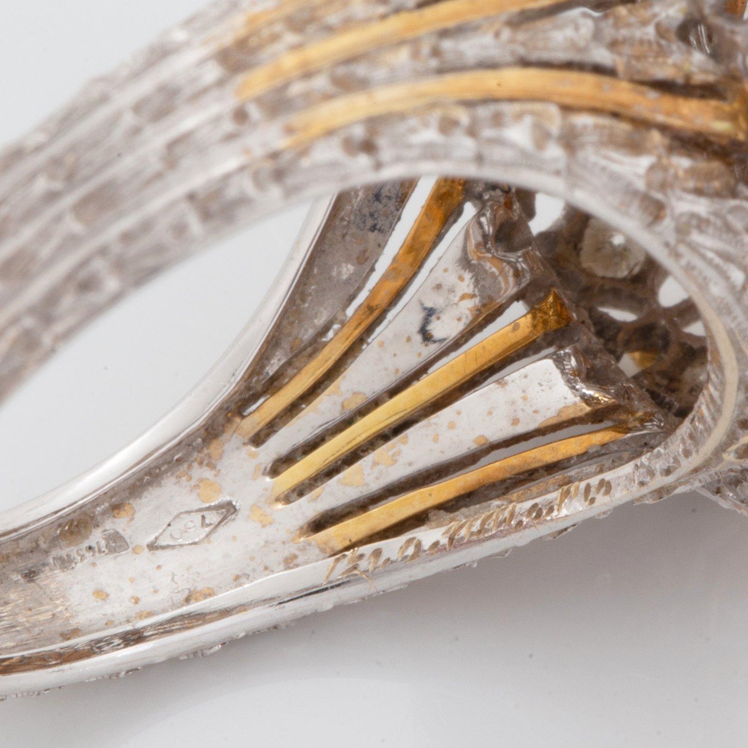 An 18K gold ring set with a cultured pearl and round brilliant-cut diamonds.