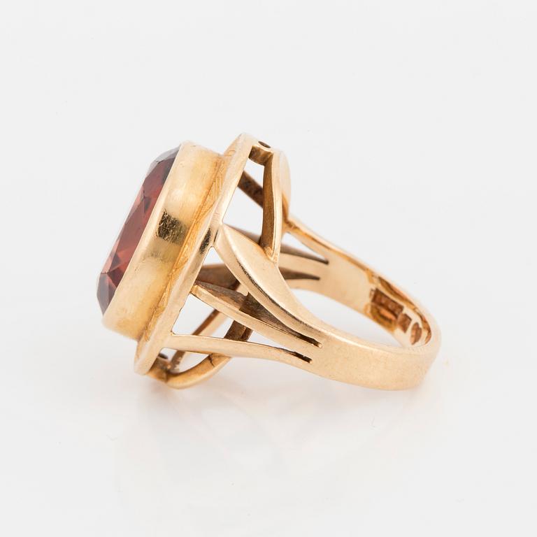 A ring with a faceted brown stone.