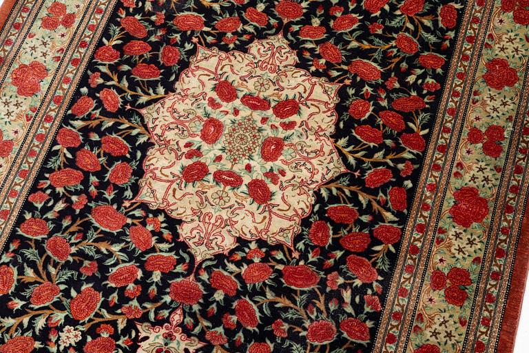 A signed silk Qum rug. c. 154 x 103 cm.