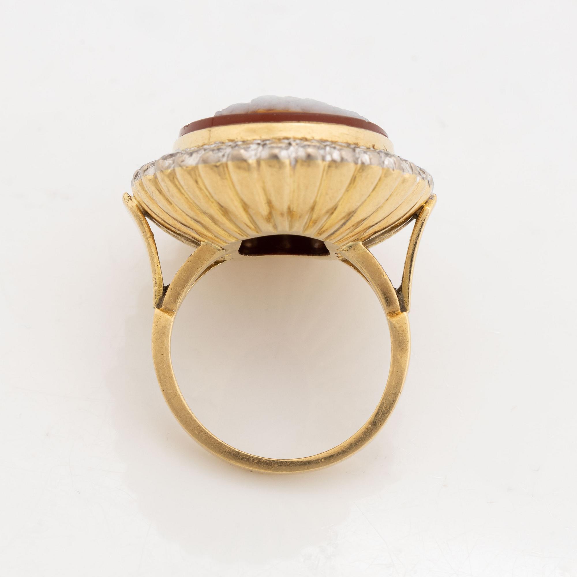 An 18K gold ring set with a hardstone cameo.