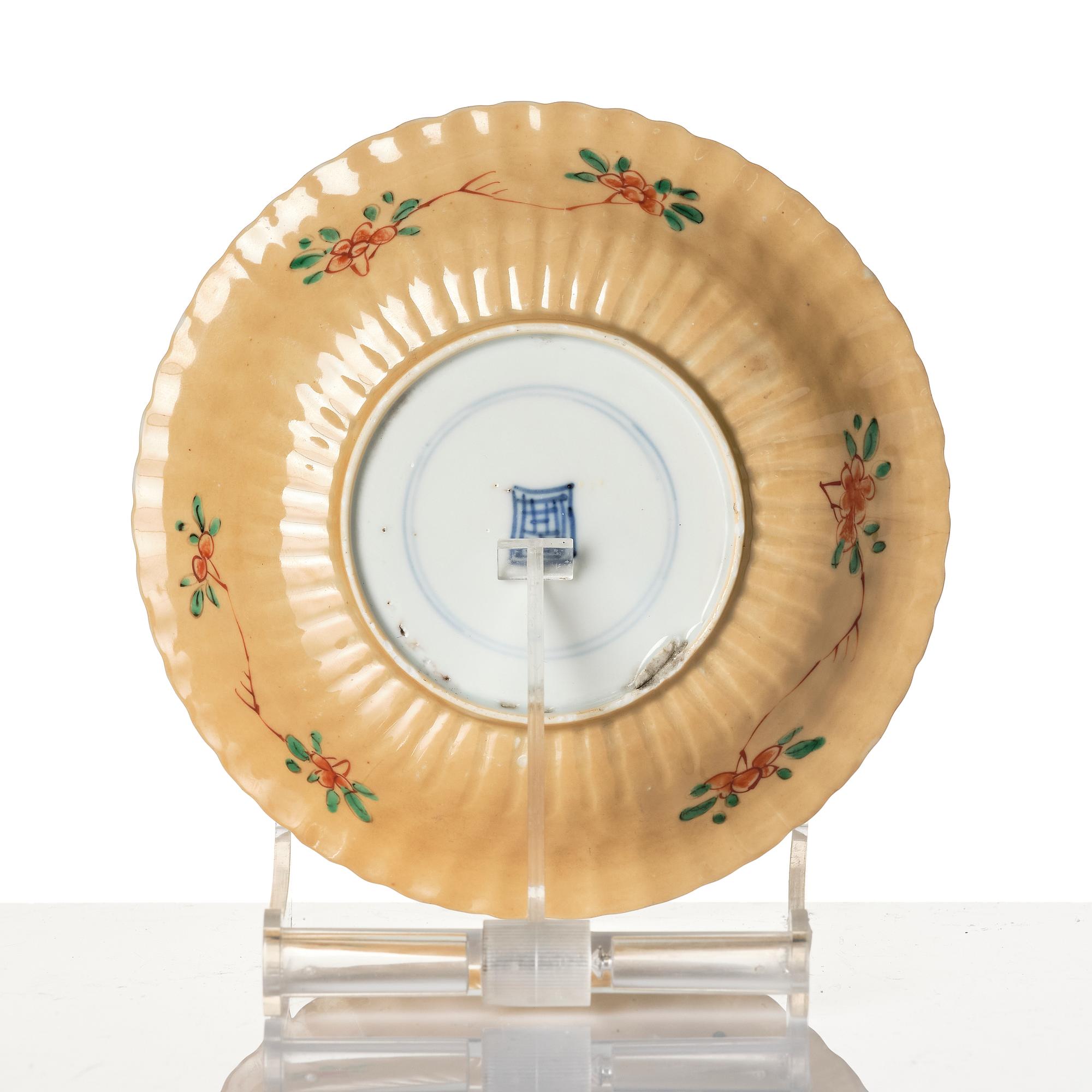 A Chinese iron red porcelain cup with saucer and a small famille verte dish, Qing dynasty, Kangxi (1662-1722).