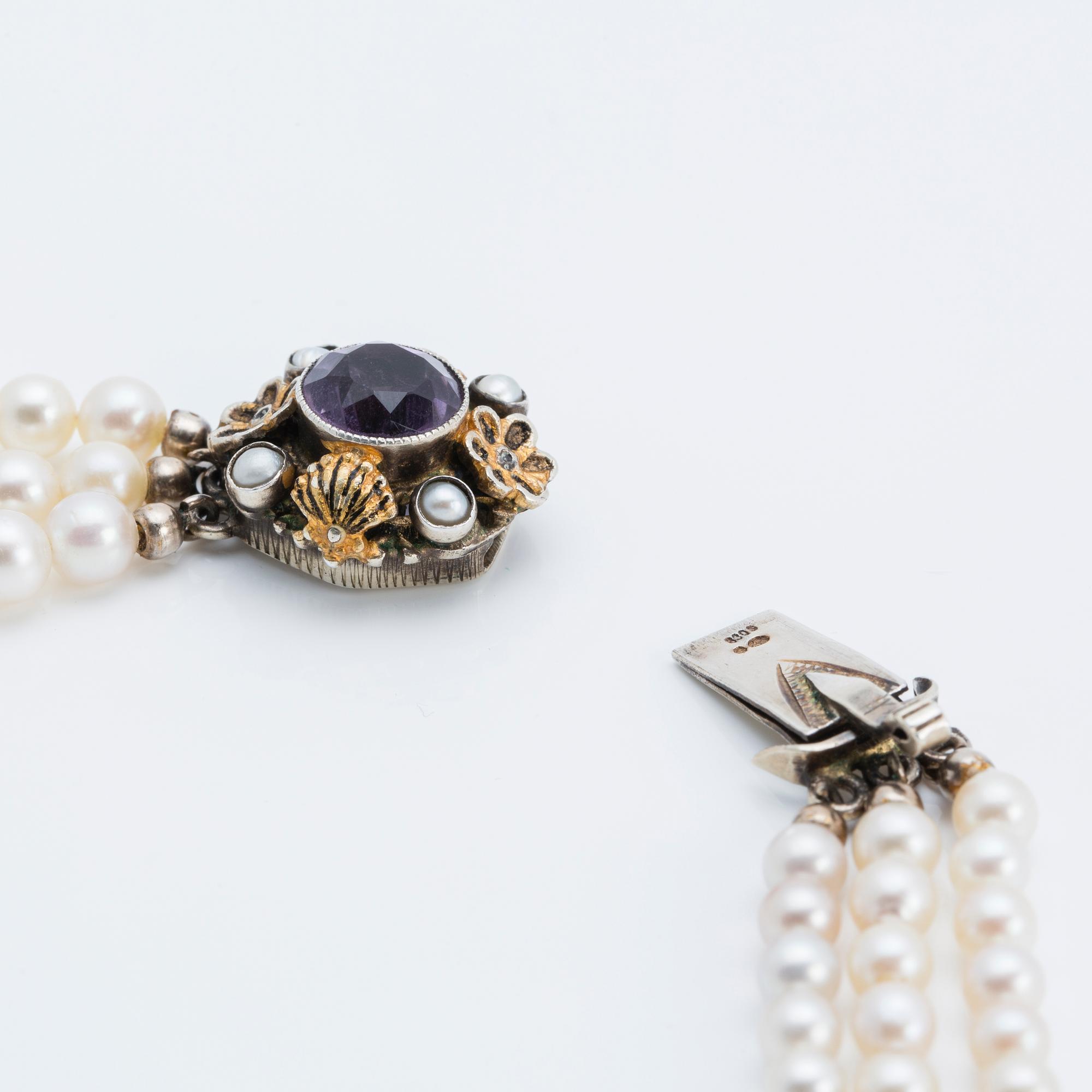 A cultured saltwater pearl collier with silver lock with purple faceted amethyst.