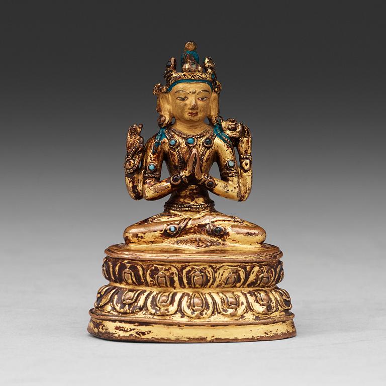 A gilt copper alloy four armed Tibetan figure of Shadakshari Lokeshvara, 16th Century or earlier.