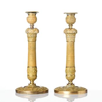 300. A pair of French Empire ormolu candlesticks, ca 1820's.