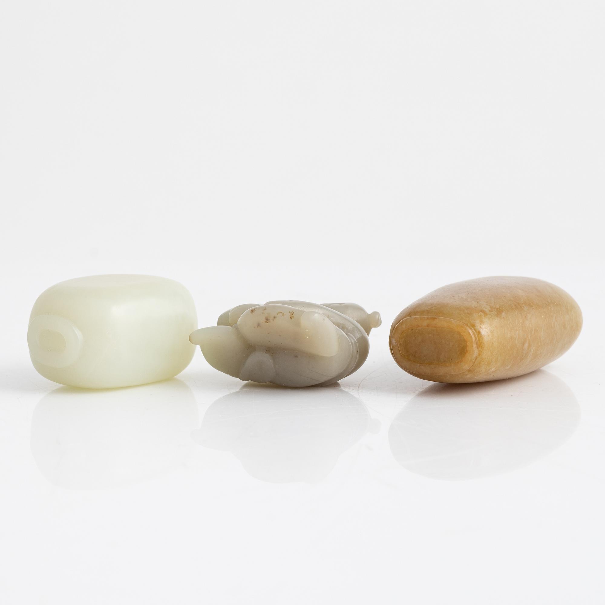 Two snuff bottles and a figurine, nefrit and green stone, China, 20th century.