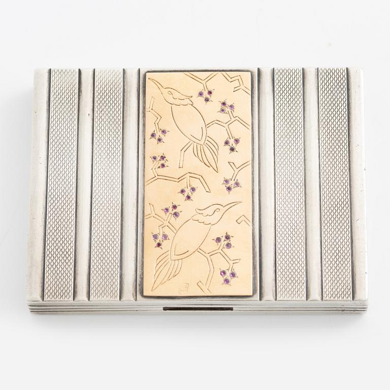 Puderdosa, silver samt guld. Med dekor av fåglar och rosa stenar.