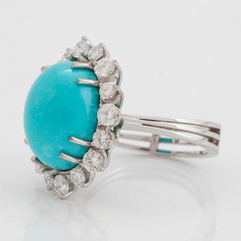 An 18K white gold ring set with a cabochon-cut turquoise and round brilliant-cut diamonds.