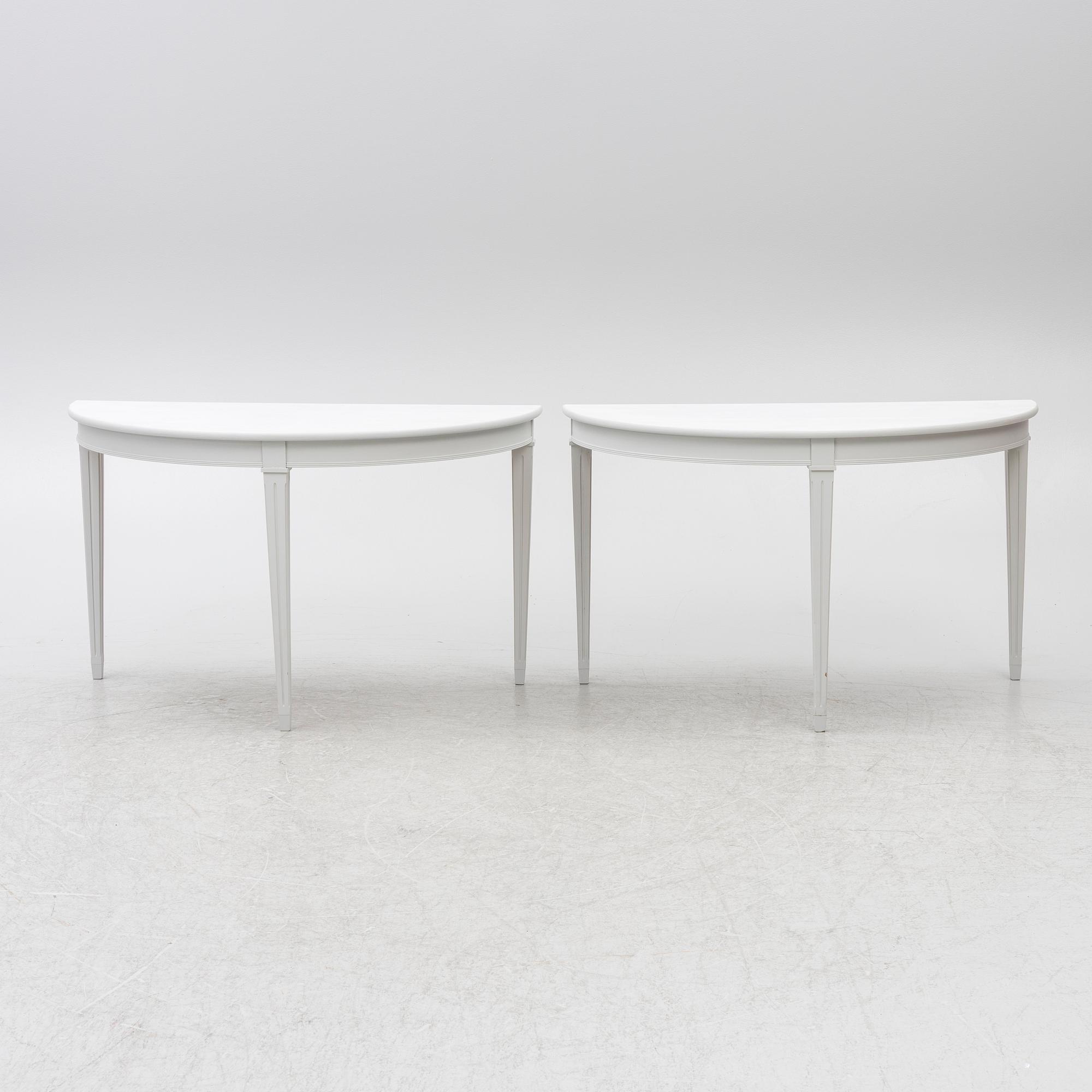 A pair of crescent shaped tables, 20th century.