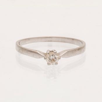 An 18K white gold ring with a round brilliant cut diamond.