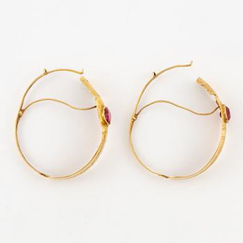 A pair of earrings in 18K gold with red glass, 9th century.