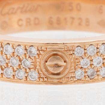 A Cartier "Love" ring in 18K rose gold with pavé-set round brilliant-cut diamonds.