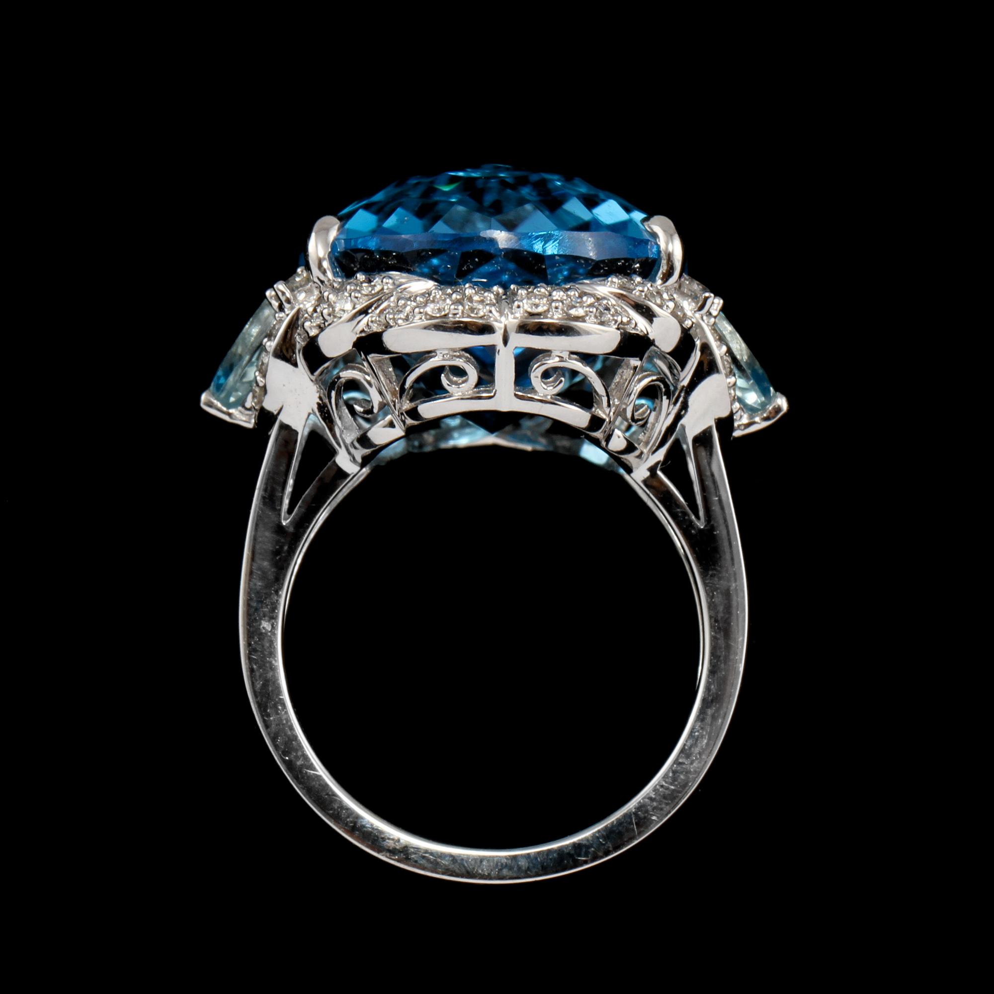 RING, 18k vitguld med checkerslipad blå topas, 2 fasettslipade akvamariner och 68 briljantslipade diamanter. Vikt 14g.