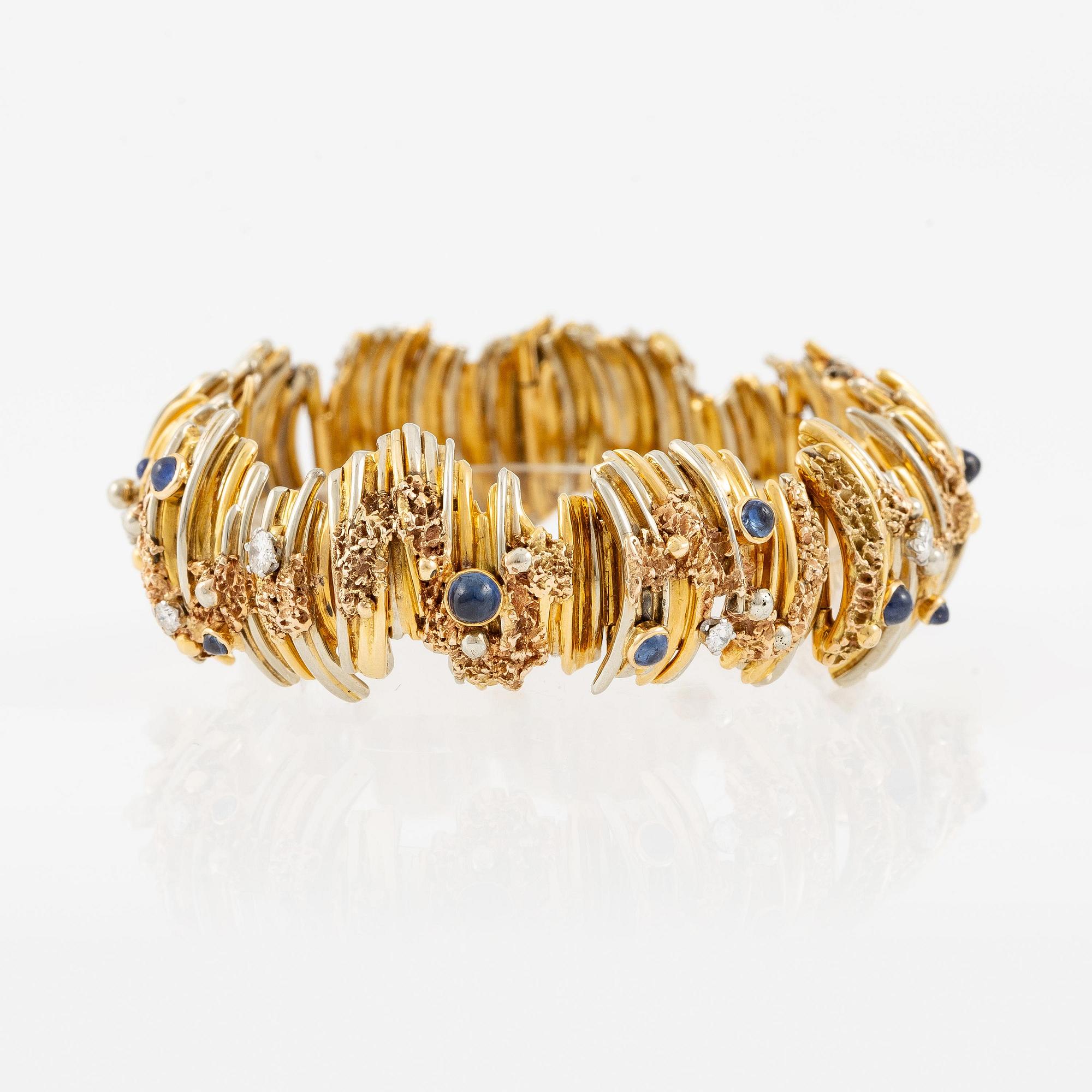 An 18K gold bracelet set with round brilliant-cut diamonds and cabochon-cut sapphires.
