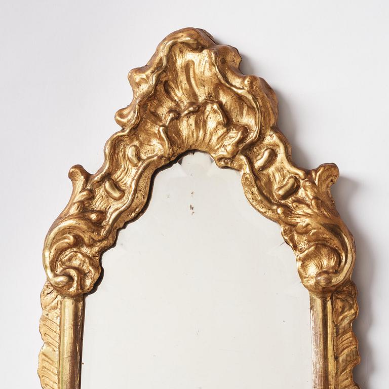 A pair of presumably German rococo giltwood one-branch mirrored wall-sconces, mid 18th century.