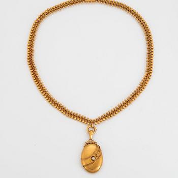 An 18K gold locket set with a pearl and an 18K gold chain.