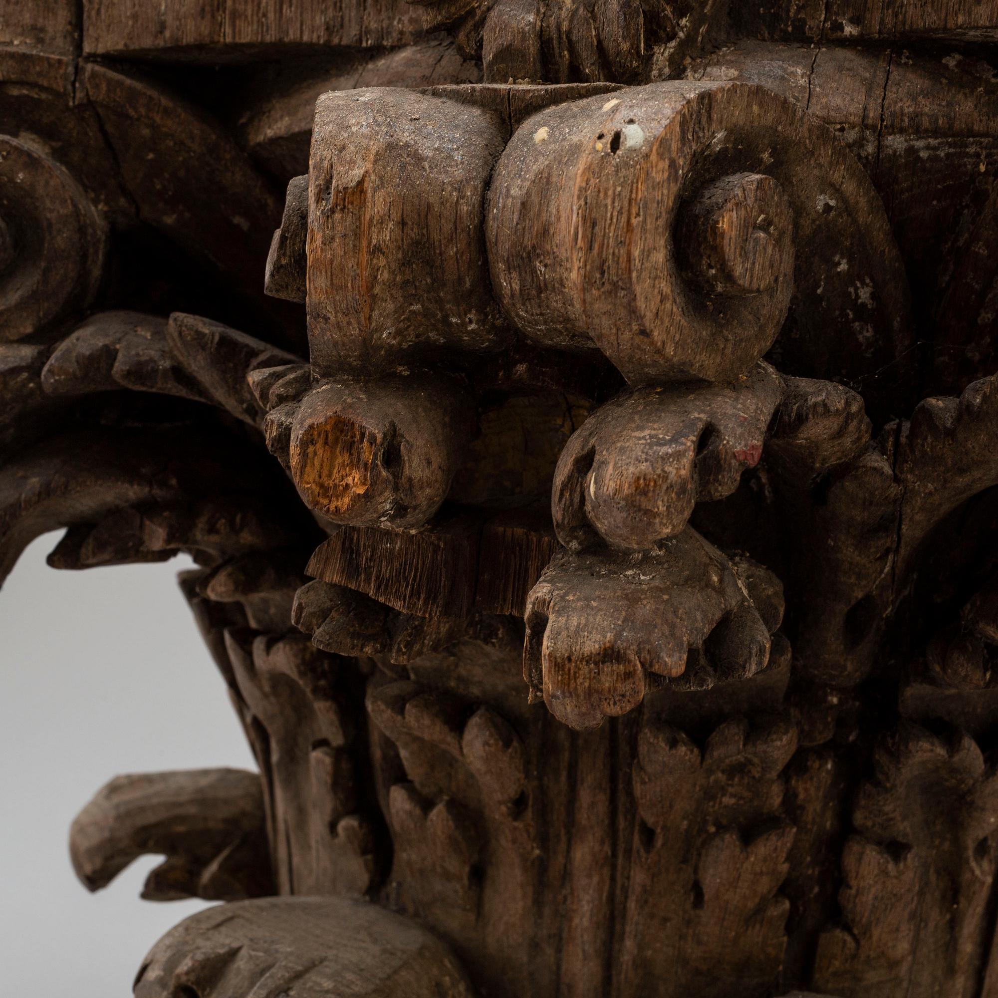 An 18th century carved wood corinthian capital.