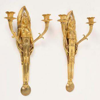 A pair of French Empire two-branch ormolu wall lights, early 19th century,.