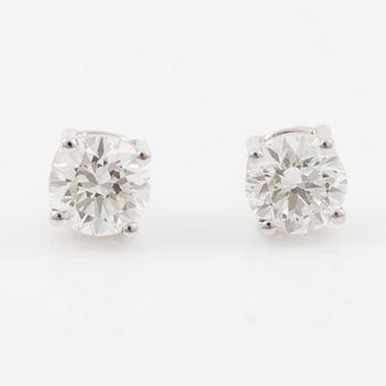 A pair of earrings in 18K white gold set with two round brilliant-cut diamonds.