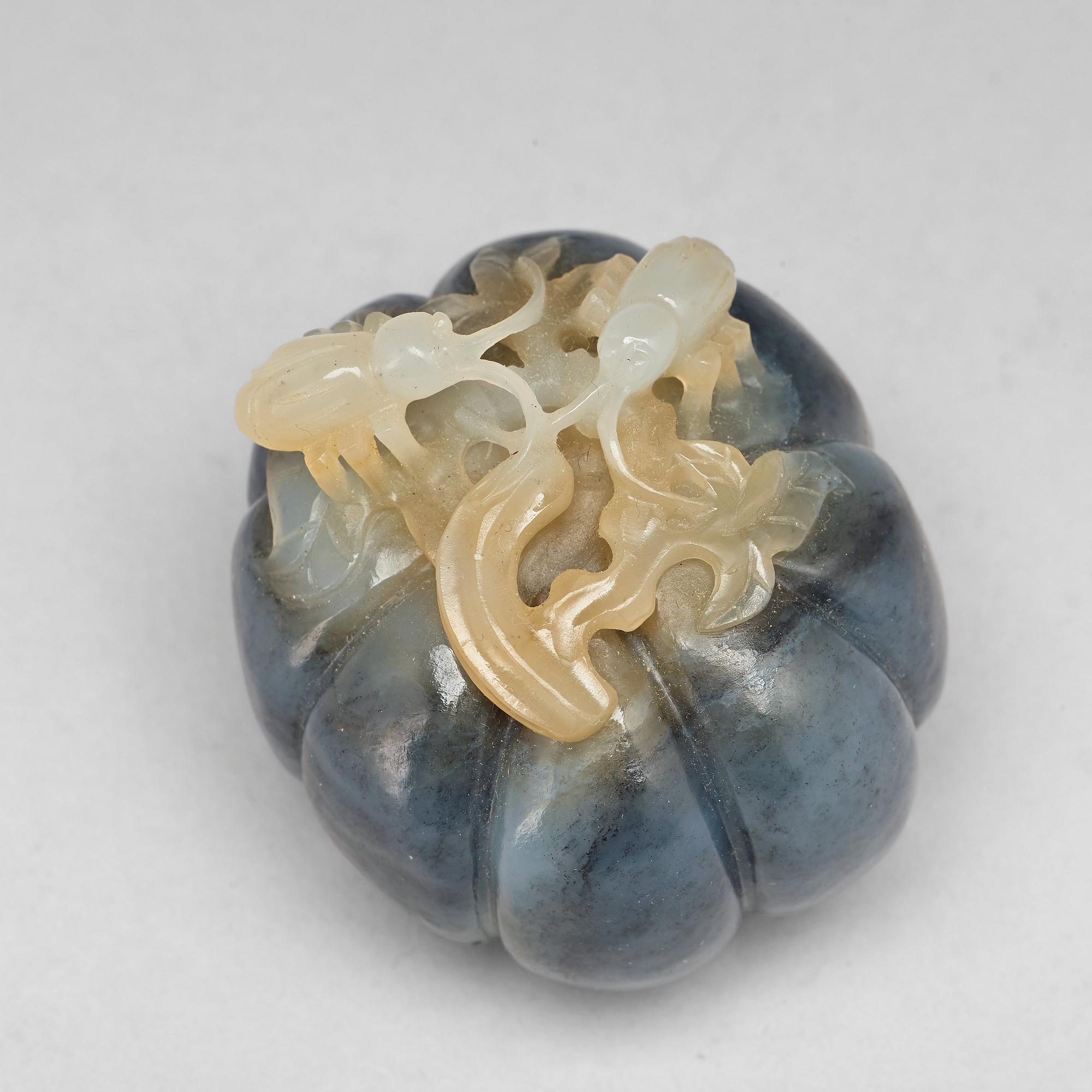 A Chinese nephrite sculpture of insects on a fruit.