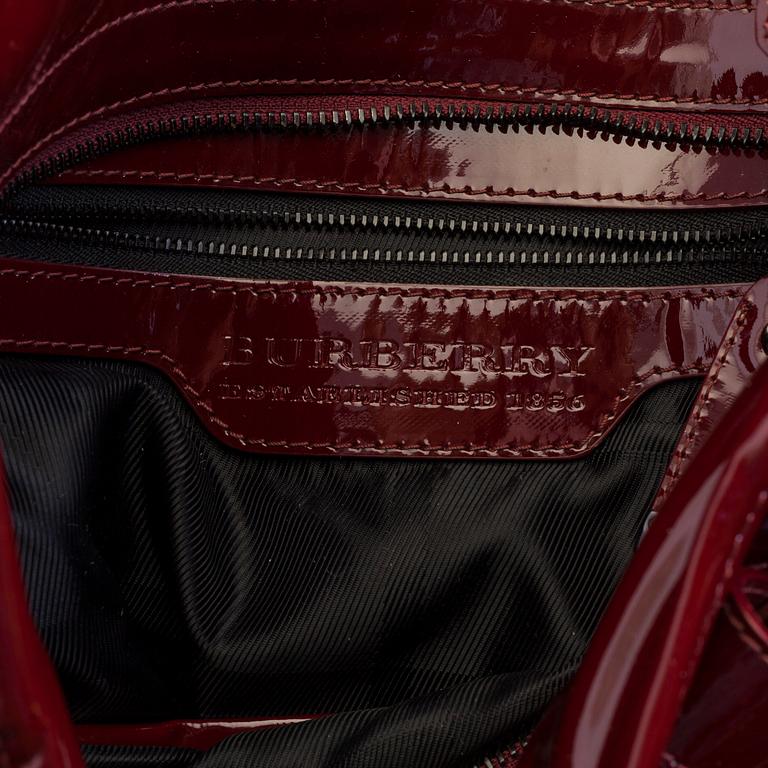 A darkred lacquer leather handbag by Burberry Prorsum.