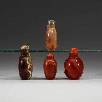 A set of four glass and stone snuff bottles with stoppers.