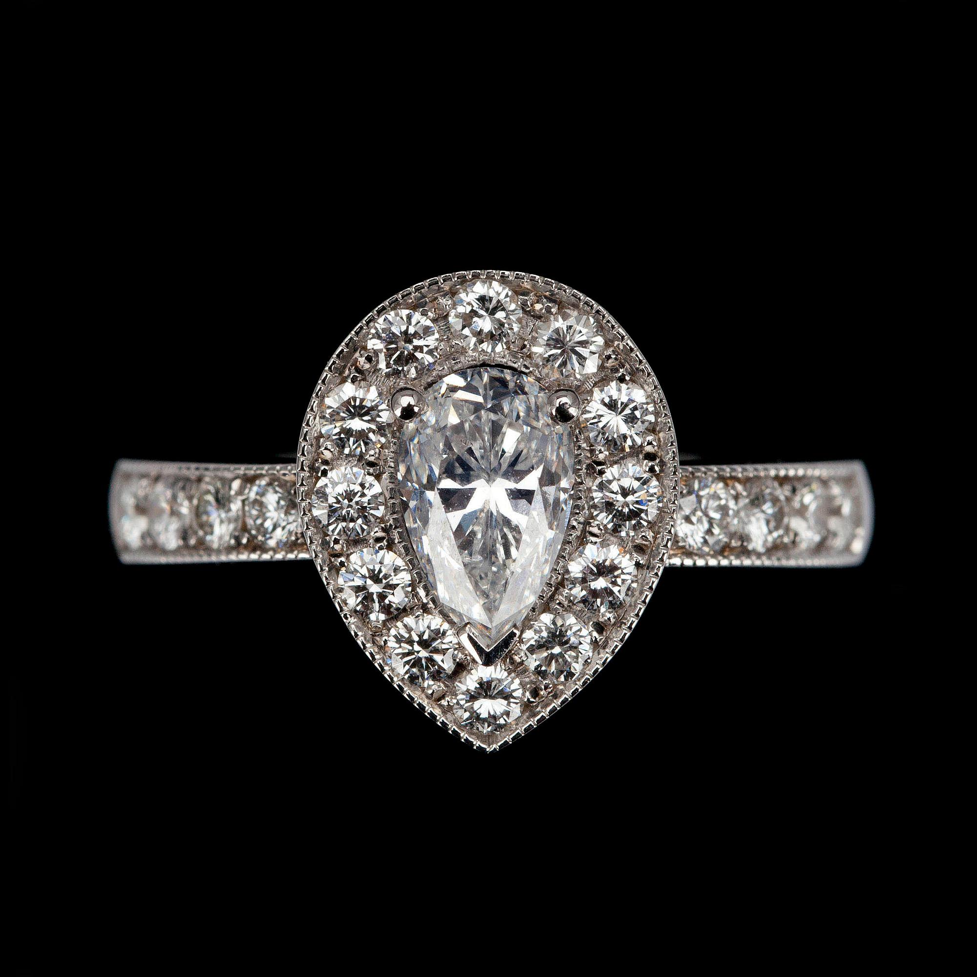RING, vitguld 18K, mittstenen droppslipad diamant 1,01ct, sidostenar tot. 0,65ct. G/VS. Intyg 220.