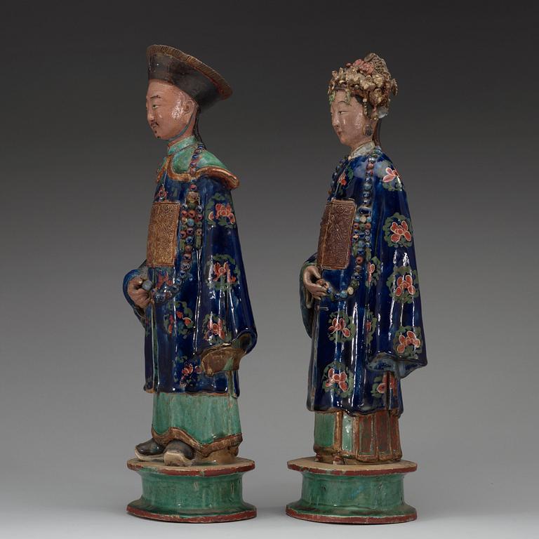 A pair of pottery figures of a Chinese official and his lady, Qing dynasty.