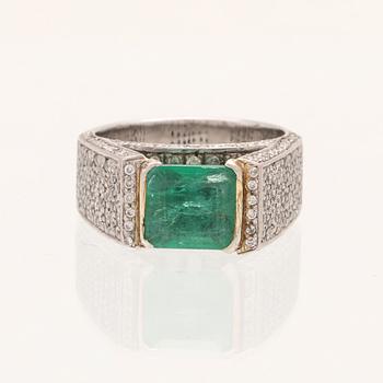 A 9K white gold ring with an emerald and brilliant cut diamonds.