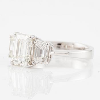 An 18K white gold ring set with three emerald-cut diamonds.