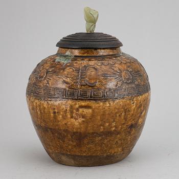 A ceramic glazed jar with wooden cover and a nephrite knob, Qing dynasty, 19th century.