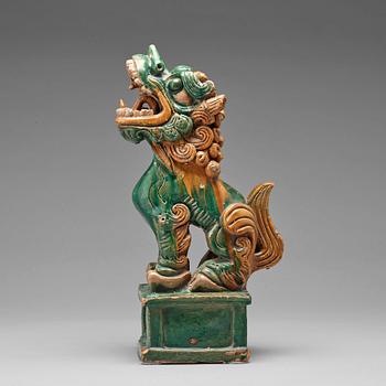 593. A green and yellow glazed pottery figure of a buddhist lion, presumably Ming dynasty.