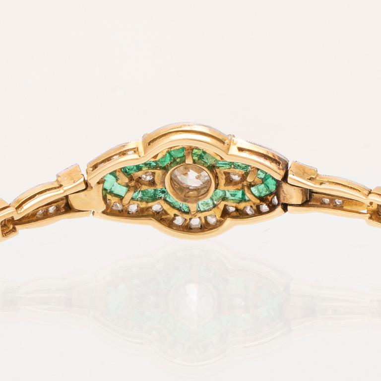 An 18K white and red gold bracelet set with emeralds between rose cut and old cut diamonds.