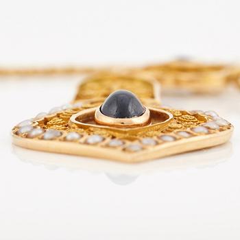 A necklace set with seed pearls, a cabochon cut sapphire, probably another sapphire and filigree work.
