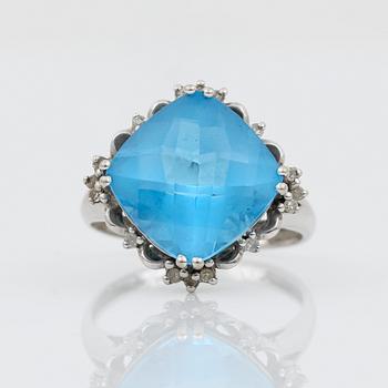 RING, 14K vitguld med blå checkerslipad topas tot ca 2.77 ct omges av små åttkantslipade diamanter. Vikt 4.56 g.
