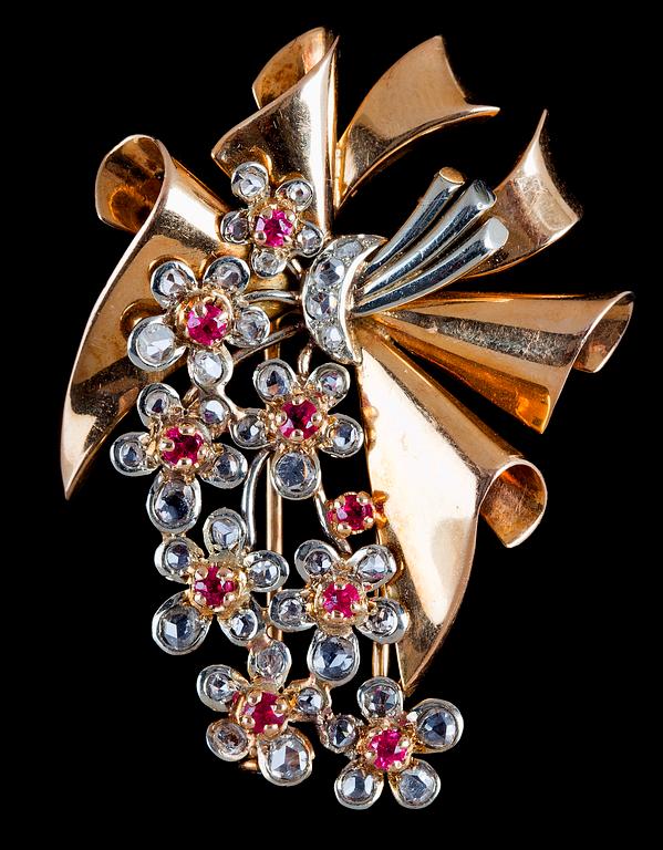 BROSCH, rosenslipade diamanter och rubiner, i form av bandrosett med blomster, 1940-tal.