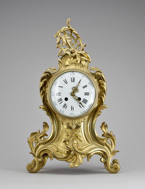 GARNITYR, BORDSPENDYL, AD Mougin samt ett par KANDELABRAR, mässing, Louis XV-stil, Frankrike, sent 1800-tal.